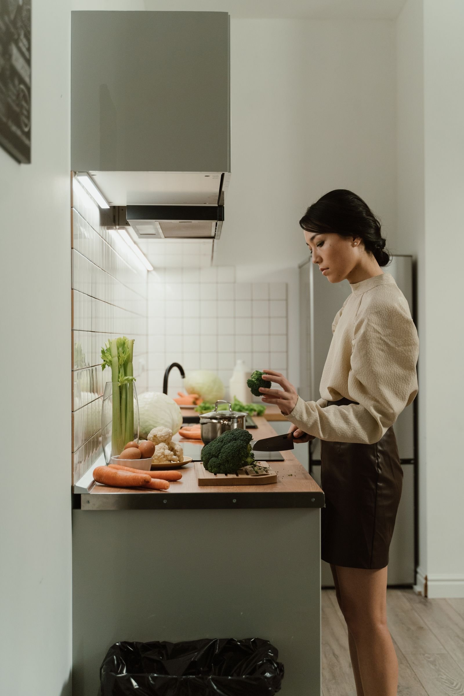 A woman preparing fresh vegetables in a bright kitchen